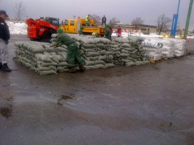 New York Air National Guard Airmen from the 107th Airlift Wing based in Niagara Falls support the stockpiling of sandbags Nov. 23, 2014, at the Erie County Community College in Williamsville, New York. The Airmen helped with the palletization, loading and onward movement of the sandbags destined for response efforts following the warmer temperatures in Western New York that has raised flooding concerns across Erie County. 