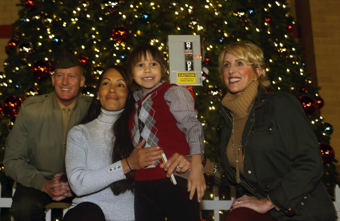 Brig. Gen. Edward D. Banta (left), commanding general of Marine Corps Installations West – Marine Corps Base Camp Pendleton and his wife (right) attend the annual christmas tree lighting ceremony with First Sgt. Christina Hunts Horse-May and her six-year old son, Joseph, at the main exchange, Nov. 22. May's husband signed their son up to flip the switch while on his current deployment with the 5th Marine Regiment.