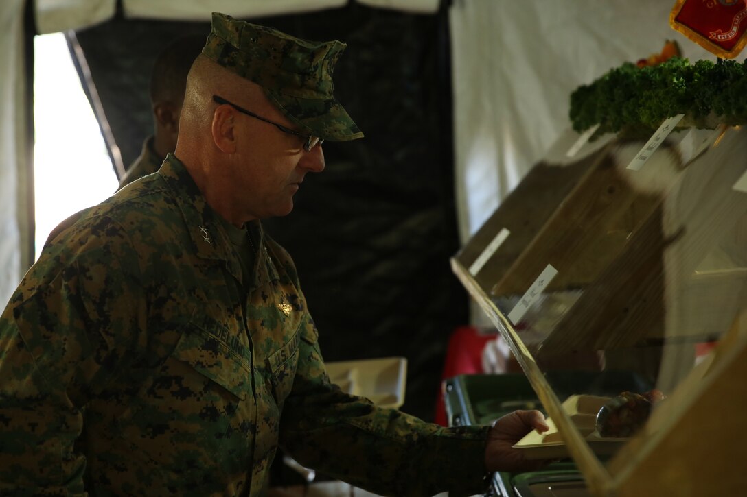 Major Gen. Robert F. Hedelund grabs a plate of chow prepared by the Marines of Marine Wing Support Squadron 274 during the W.P.T. Hill Award food service competition at Marine Corps Air Station Cherry Point, N.C., Nov. 18, 2014. Hedelund is the commanding officer of the 2nd Marine Aircraft Wing.