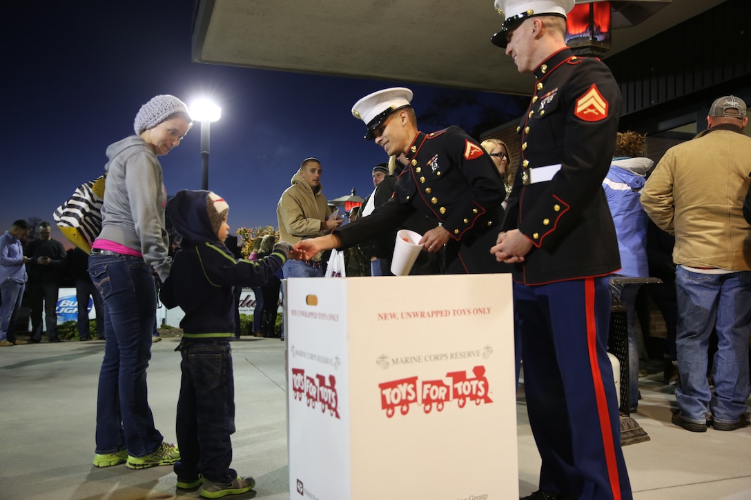 Lance Cpl. Sebastian Alli, left and Cpl. Matthew Bialy, right, collect toys and hand out raffle tickets for the Marine Corps Reserve’s Toys for Tots program during the 6th Annual Guitar Pull at Marine Corps Air Station Cherry Point, N.C., Nov. 19, 2014. Alli is a maintenance administrative specialist with Marine Aviation Logistics Squadron 14 and a native of Brooklyn, N.Y. Bialy is a consolidated automated support system technician with MALS-14 and a native of Post Falls, Idaho.