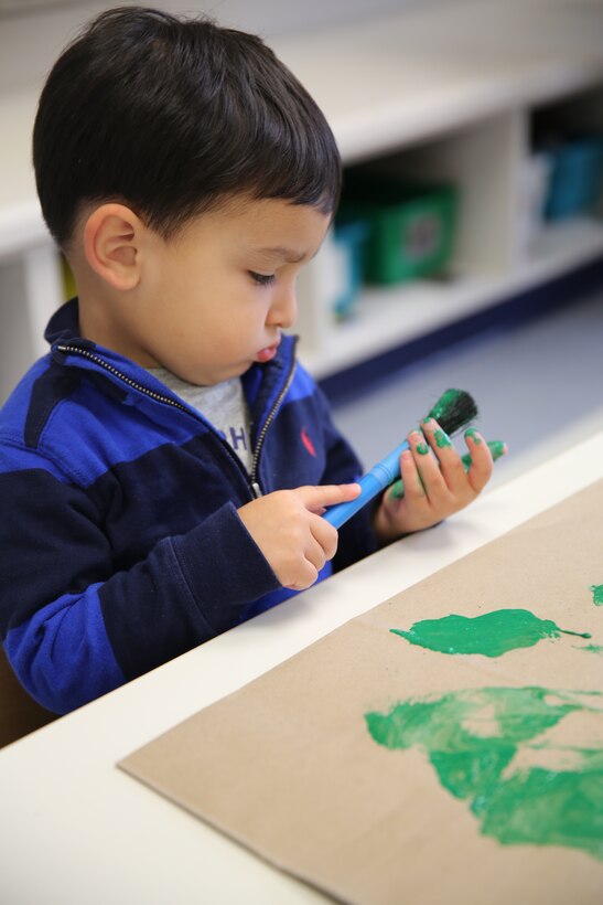 Richard N., 2, paints during activity time at the Child Development Center at Marine Corps Air Station Cherry Point, N.C., Nov. 14, 2014. Children at the CDC decorated brown paper bags for the commissary to raise awareness of the 5210 Healthy Military Children Campaign. The campaign is designed to lower obesity rates and improve overall health of military children. 