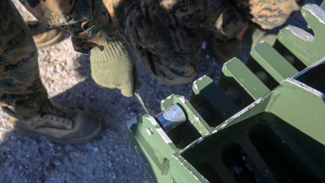 Marines with 8th Engineer Support Battalion, 2nd Marine Logistics Group use a clip to secure part of a 12-bay, double-story, medium-girder bridge at Landing Zone Dove on Marine Corps Base Camp Lejeune, N.C., Nov. 19, 2014.  Approximately 25 Marines constructed the bridge, able to support the weight of a tank, in under six hours. The training reinforced skills learned at Marine Corps combat engineering school. (Marine Corps photo by Lance Cpl. Kirstin Merrimarahajara/released)