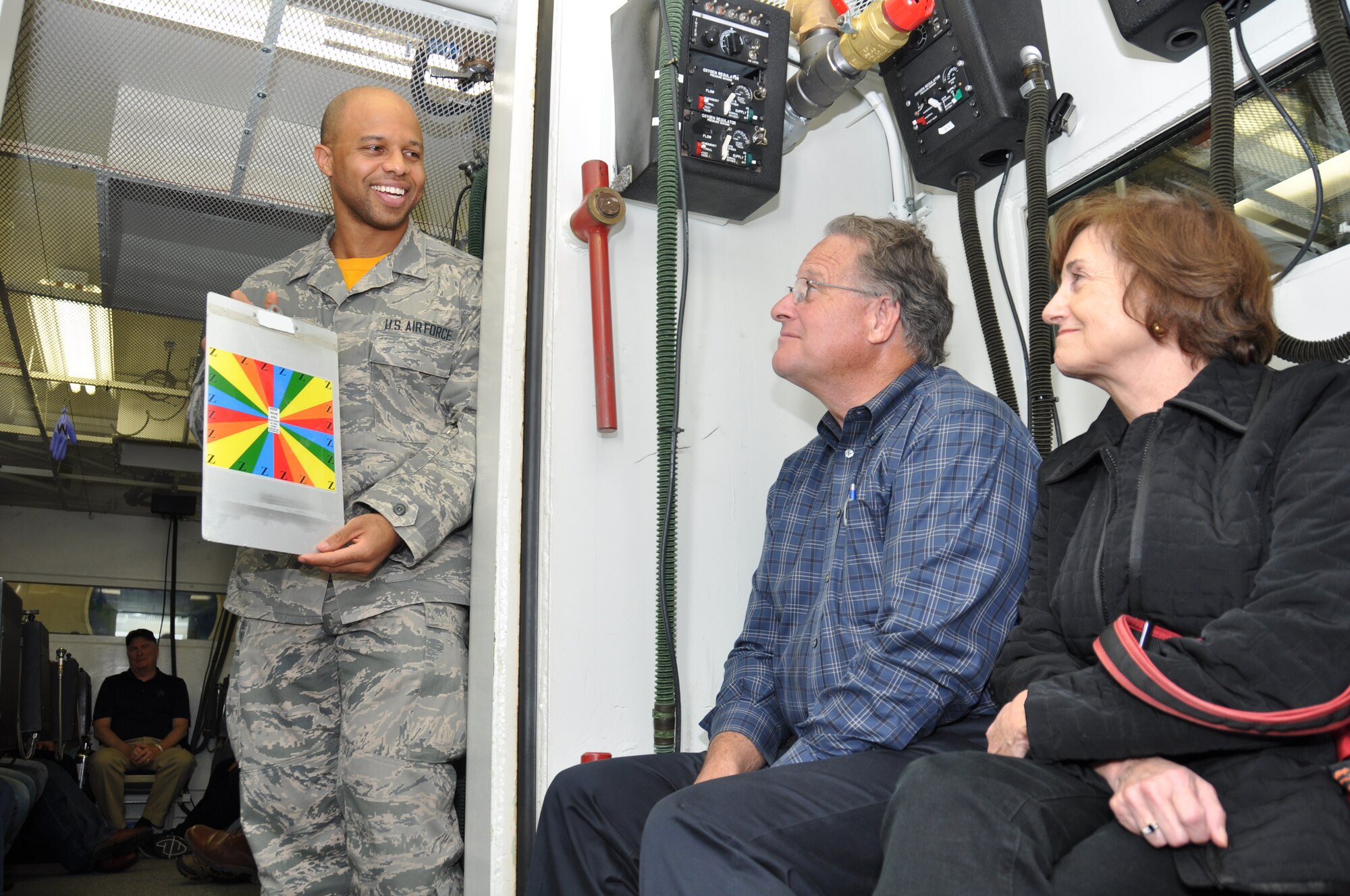 Airman 1st Class D. Wright, a 9th Physiological Support Squadron member, explains to local area business leaders on a base tour about the altitude chamber and how vision is affected when in a low oxygen environment. When in a low pressure environment people’s vision dims and they view color in daytime and low-light situations differently than usual.   (U.S. Air Force photo by Tech. Sgt. Heather Skinkle/Released)