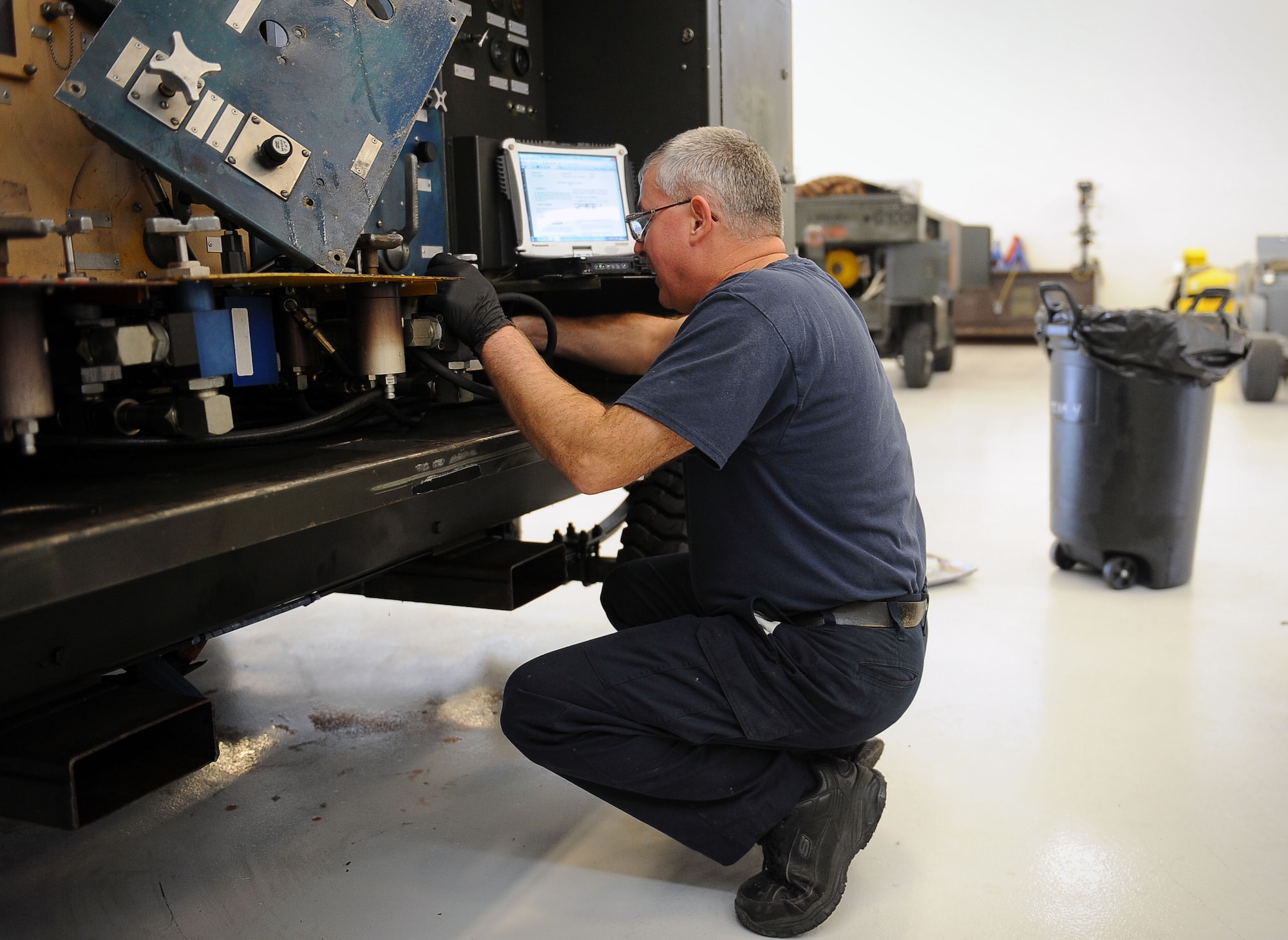 Joe Barnes, a contractor with the 57th Maintenance Group, works on a hydraulic test stand at the Aerospace Ground Equipment hangar on Nellis Air Force Base, Nev., Nov. 20, 2014. AGE workers perform scheduled and unscheduled maintenance on AGE as well as inspect, test and operate AGE to determine equipment serviceability and proper operation. (U.S. Air Force photo by Airman 1st Class Rachel Loftis)  