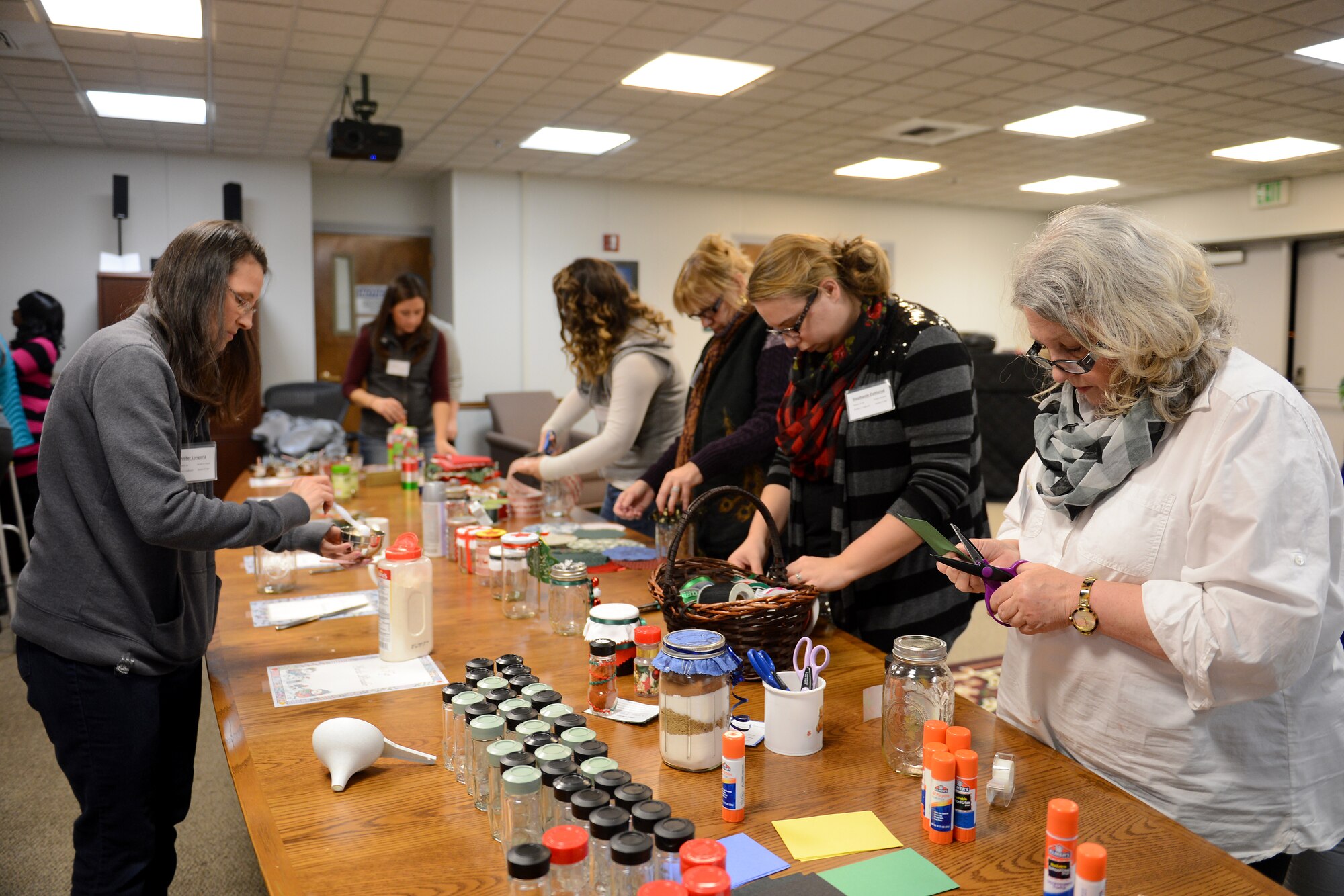 Craft Tea attendants cut out designs and fill jars with separate ingredients Nov. 22, 2014, during the Craft Tea event at the Chapel Support Center at Joint Base Lewis-McChord, Wash. The attendants were given muffins and tea, along with a folder including additional instructions and ideas for homemade gifts, allowing them to create their own crafts at home. (U.S. Air Force photo/Airman 1st Class Keoni Chavarria)
