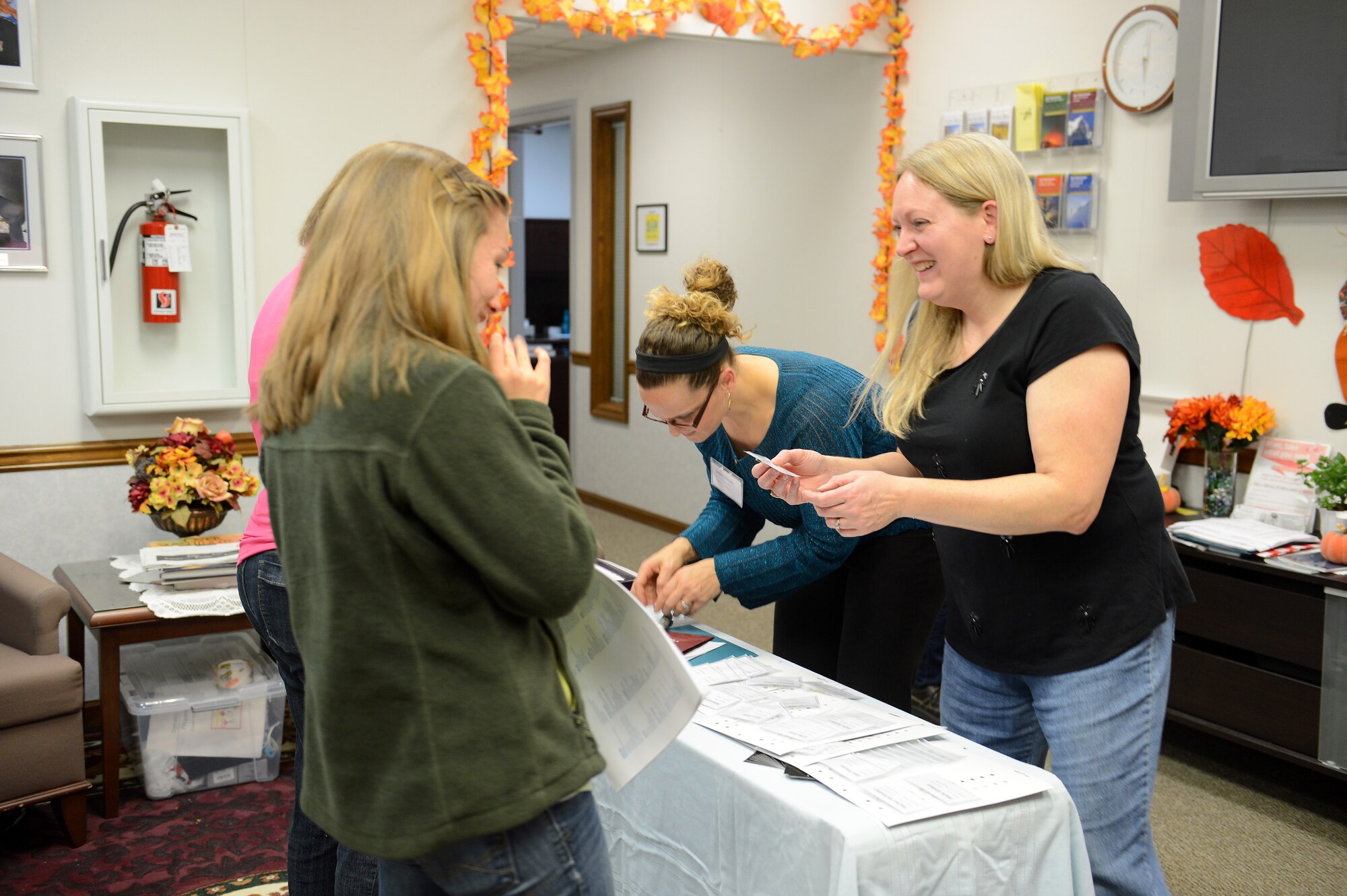 Nena Shipman (right), Protestant Women of the Chapel hospitality coordinator helps attendants sign in Nov. 22, 2014, during the Craft Tea event at the Chapel Support Center at Joint Base Lewis-McChord, Wash. The Craft Tea event allowed the women in attendance an opportunity to relax and drink tea, while making inexpensive crafts using items such as recyclables. (U.S. Air Force photo/Airman 1st Class Keoni Chavarria)