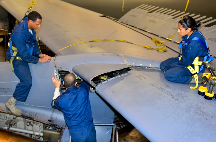 Crew chiefs with the 2nd Maintenance Squadron install a B-52H Stratofortress leading edge fairing on Barksdale Air Force Base, La., Nov. 24, 2014. The leading edge fairing allows access to all fuel lines, hydraulic lines, electrical wires and cables running from the wing of the aircraft to the cockpit.  (U.S. Air Force photo/Airman 1st Class Mozer O. Da Cunha) 