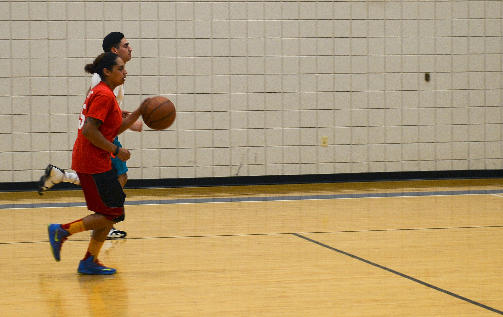 Senior Airman Emery Buckner, 22nd Force Support Squadron customer support journeyman, dribbles the ball down court during a pickup basketball game, Nov. 18, at McConnell Air Force Base, Kan. Buckner likes to spend her free time at the base gym playing basketball to relax her nerves from a stressful work week. (U.S. Air Force photo/Airman 1st Class Colby L. Hardin)