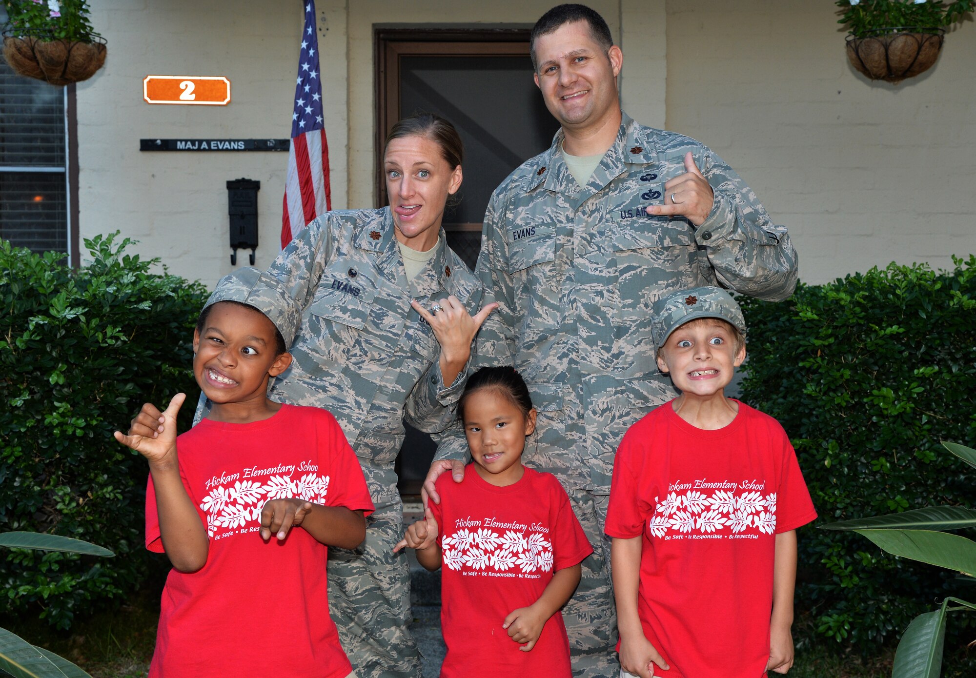 U.S. Air Force Maj. Amanda Evans, 15th Comptroller Squadron commander, and U.S. Air Force Maj. Brian Evans, Special Operations Command Pacific air operations planner (back), Trevor, Katelyn and Parker (front) make silly faces and show shaka signs for a photo in front of their home at Joint Base Pearl Harbor-Hickam, Hawaii, Nov. 21, 2014. Amanda and Brian adopted Trevor and Katelyn, and Parker is their biological son. Their unique story of adoption and balancing life at home and on duty reflect the strength and diversity of military families. November highlights families such as the Evans with its designation as Month of the Military Family and National Adoption Month. (U.S. Air Force photo by Staff Sgt. Alexander Martinez/Released)