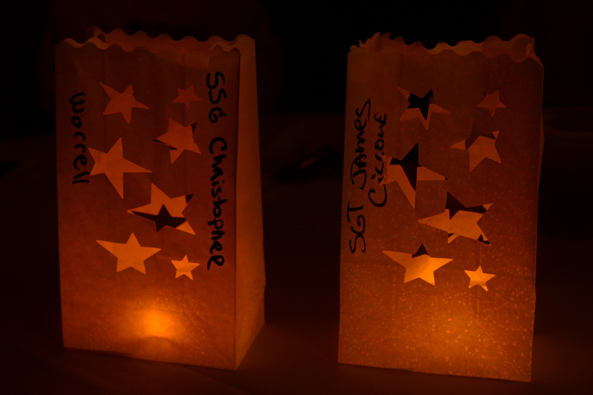 Gold Star family members light luminaries with their fallen Service members’ names on them during the fourth annual Thanks for Giving potluck social at the Lakeside Grill at Fort Eustis, Va., Nov. 20, 2014. The luminaries featured stars cut out to represent the Gold Star families and the ultimate sacrifices their loved ones made. (U.S. Air Force photo by Staff Sgt. Teresa J. Cleveland/Released)
