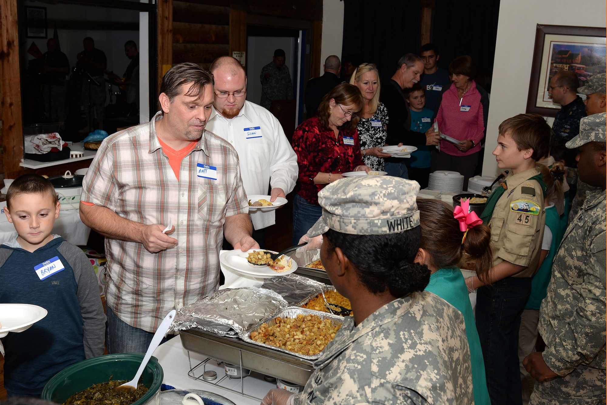 Members of the 688th Rapid Port Opening Element, 833rd Transportation Battalion, 597th Transportation Brigade; Fort Eustis Boy Scouts Troop 45; and Girl Scouts of the Colonial Coast serve food and beverages during the fourth annual Thanks for Giving potluck social at the Lakeside Grill at Fort Eustis, Va., Nov. 20, 2014. Families of fallen Service members, known as Gold Star families, traveled from across the Hampton Roads are to share personal dishes and offer support to each other. (U.S. Air Force photo by Staff Sgt. Teresa J. Cleveland/Released)