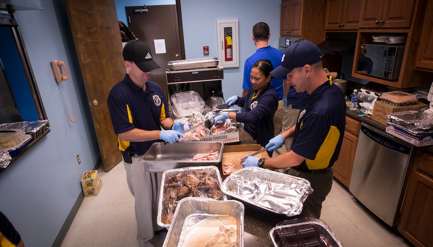 Members of the 336th Recruiting Squadron prepare food during a Thanksgiving lunch for Airmen E-4 and below Nov. 20, 2014, at Moody Air Force Base, Ga. The 336th RCS Airmen helped carve the turkey and ham. (U.S. Air Force photo by Senior Airman Sandra Marrero/Released)
