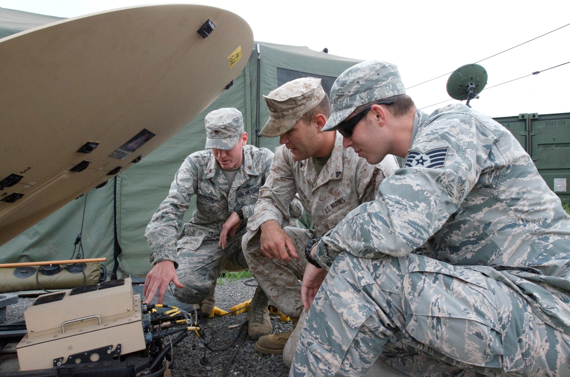 (From left to right) Maj. Kyle Johnson, Africa Command detachment commander, 2nd Joint Communications Squadron, Joint Communications Support Element, works with Marine Corps Cpl. Kameron French and Air Force Staff Sgt. Zachary Myers to set up tactical communication equipment at Barclay Training Center, Monrovia, Liberia. Johnson and his joint team established command and control capabilities for all of Operation United Assistance. (U.S. Air Force photo)