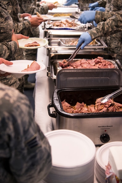 Moody senior NCOs and officers serve food to Airmen during a Thanksgiving lunch Nov. 20, 2014, at Moody Air Force Base, Ga. The traditional meal included turkey, ham, cranberry sauce, mashed potatoes and dessert. (U.S. Air Force photo by Senior Airman Sandra Marrero/Released)
