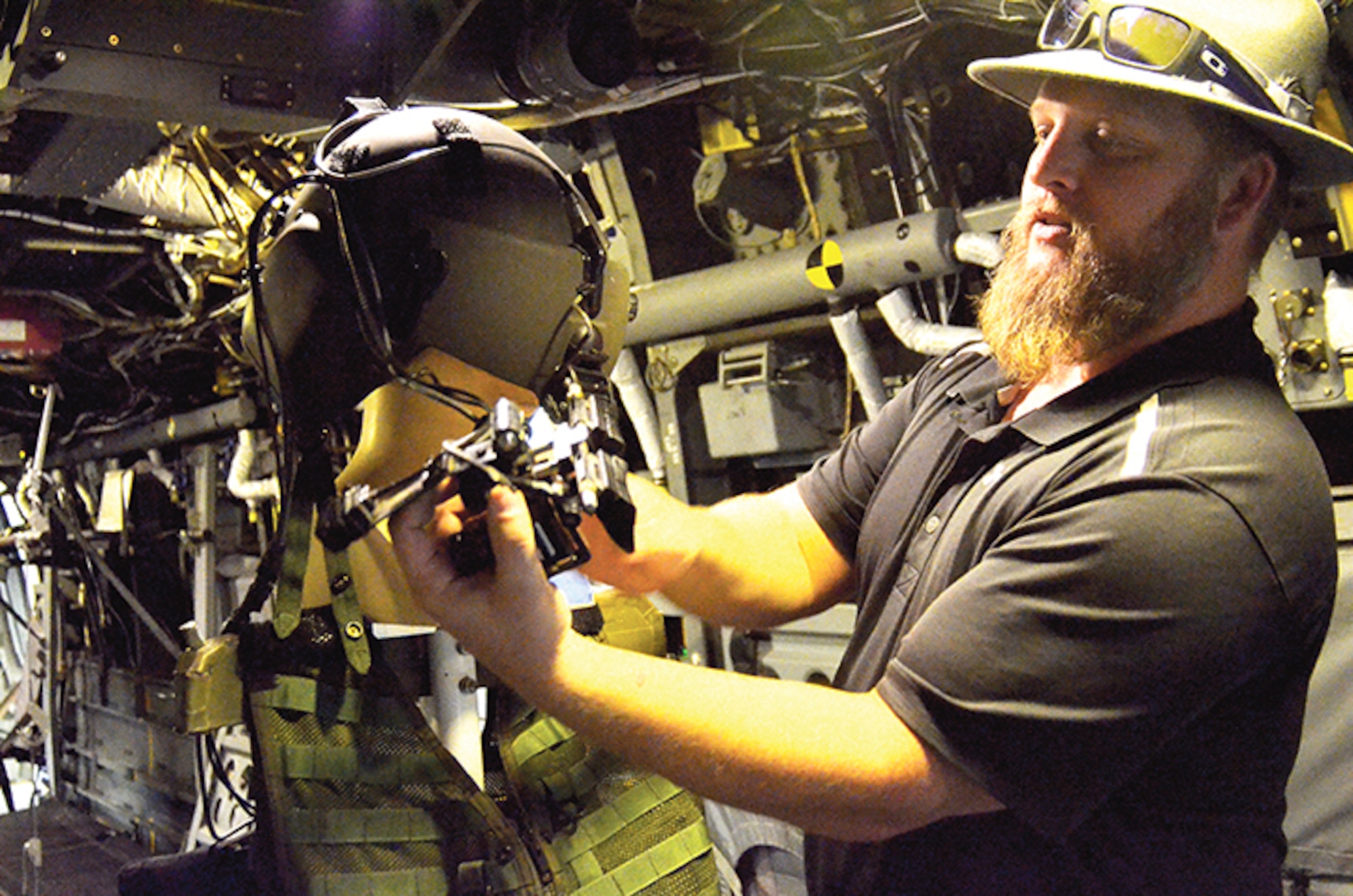 Craig Rhodes, who works at the Training Development Flight, shows off the capabilities of the virtual reality headset in the COFT, a CV-22 training device. (Photo by Lee Ross)