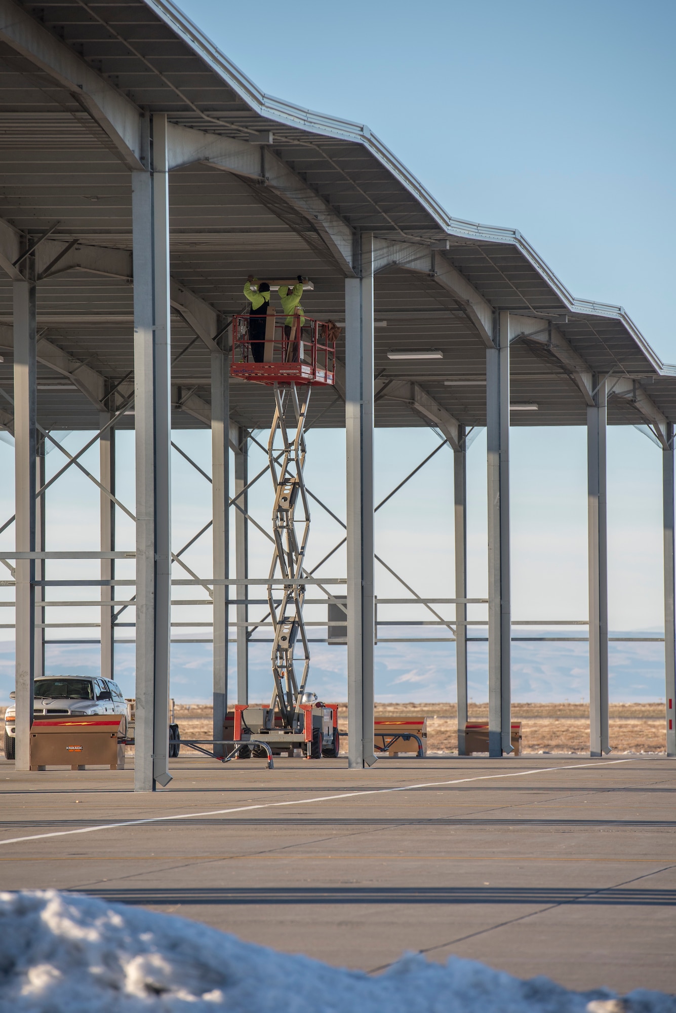 Civilian contractors work on installing lights in the sunshades at Mountain Home Air Force Base, Idaho, Nov. 24, 2014. The completion goal for all the new sunshade lighting is January 2015. (U.S. Air Force photo by Airman 1st Class Jessica Smith/RELEASED)