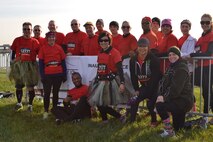 709th Airlift Squadron loadmaster, Tech. Sgt. Carolina Rodriquez (center), wears her tutu while standing with the team she helped organize to run the "Across the Bay 10K" race, this Nov. Rodriquez and her team raised nearly $2,800 dollars for the War Dogs Making it Home charity, which pairs war dogs with war veterans who are struggling with PTSD and TBI.