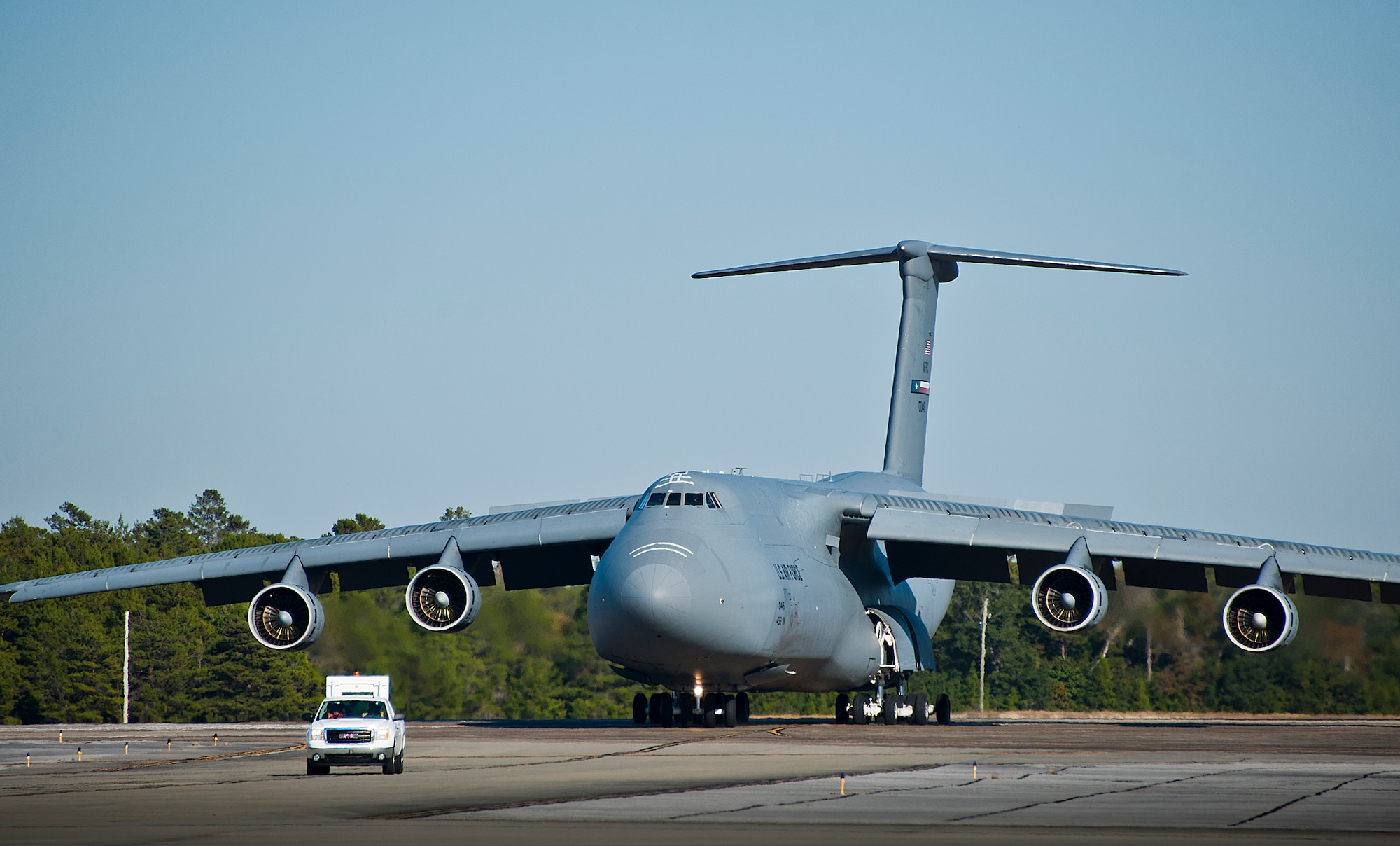 A 96th Test Wing transportation alert vehicle leads a 433rd Airlift Wing C-5 Galaxy from Joint Base San Antonio with passengers and equipment to a parking area on Eglin Air Force Base, Fla.  The reserve aircrew brought home Soldiers and equipment from the Army’s 7th Special Forces Group.  (U.S. Air Force photo/Samuel King Jr.)