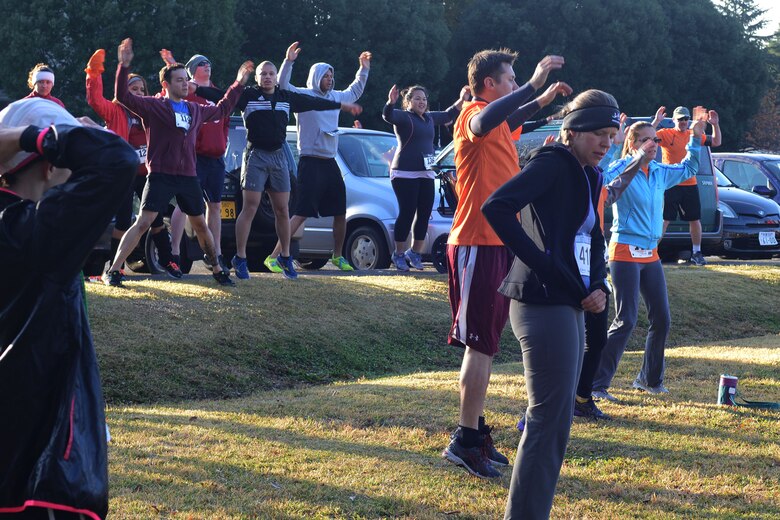 Runners at the Turkey Trot 5k Fun Run do warm up exercises before running the race at Yokota Air Base, Japan, Nov. 21, 2014. Booths were set up and prizes were given out to participants during the race. (U.S. Air Force photo by Tech. Sgt. Melissa K. Mekpongsatorn/Releasable)