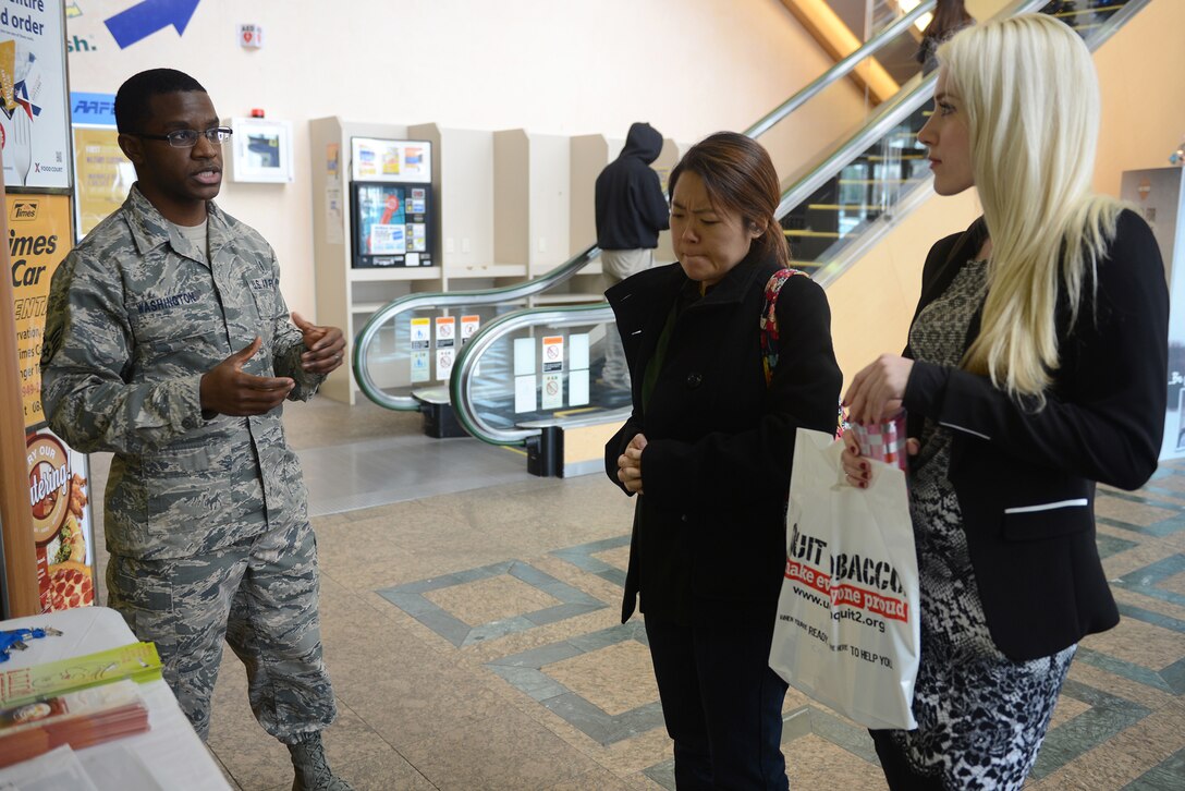 Staff Sgt. Anthony Washington, 374th Aerospace Medicine Squadron health promotion flight NCO in charge, explains the Great American Smokeout Campaign and its goals to base residents at Yokota Air Base, Japan, Nov. 20, 2014. The campaign encourages people to quit smoking for one day as a proof of concept. (U.S. Air Force photo by Airman 1st Class David C. Danford/Released)