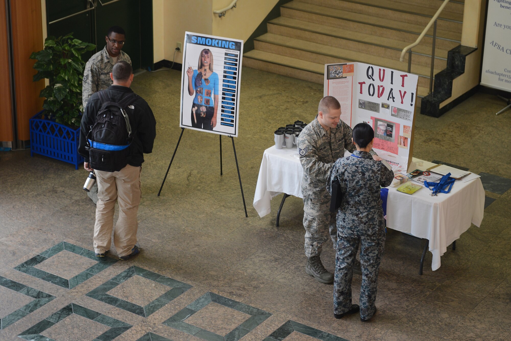 Staff Sgts. Anthony Washington, 374th Aerospace Medicine Squadron health promotion flight NCO in charge, and Michael Miklosi, 374th Dental Squadron lab technician, promote the Great American Smokeout Campaign at Yokota Air Base, Japan, Nov. 20, 2014. The campaign provides resources that aim to counteract tobacco use, the leading cause of preventable death in the U.S. (U.S. Air Force photo by Airman 1st Class David C. Danford/Released)