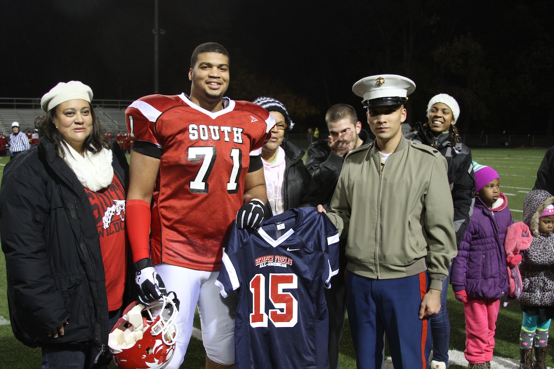 Rob Dowdy, a lineman with the Westerville South High School football team, poses for a photo alongside his mother and U.S. Marine Corps Sgt. Joshua Baker, a Marine recruiter for the Westerville, Ohio, area. Dowdy has been officially selected to play in the Marine Corps Semper Fidelis All American Bowl, which will be held Jan. 4, 2015 in Carson, California. (U.S. Marine Corps photo by Cpl. Kyle Welshans/Released)