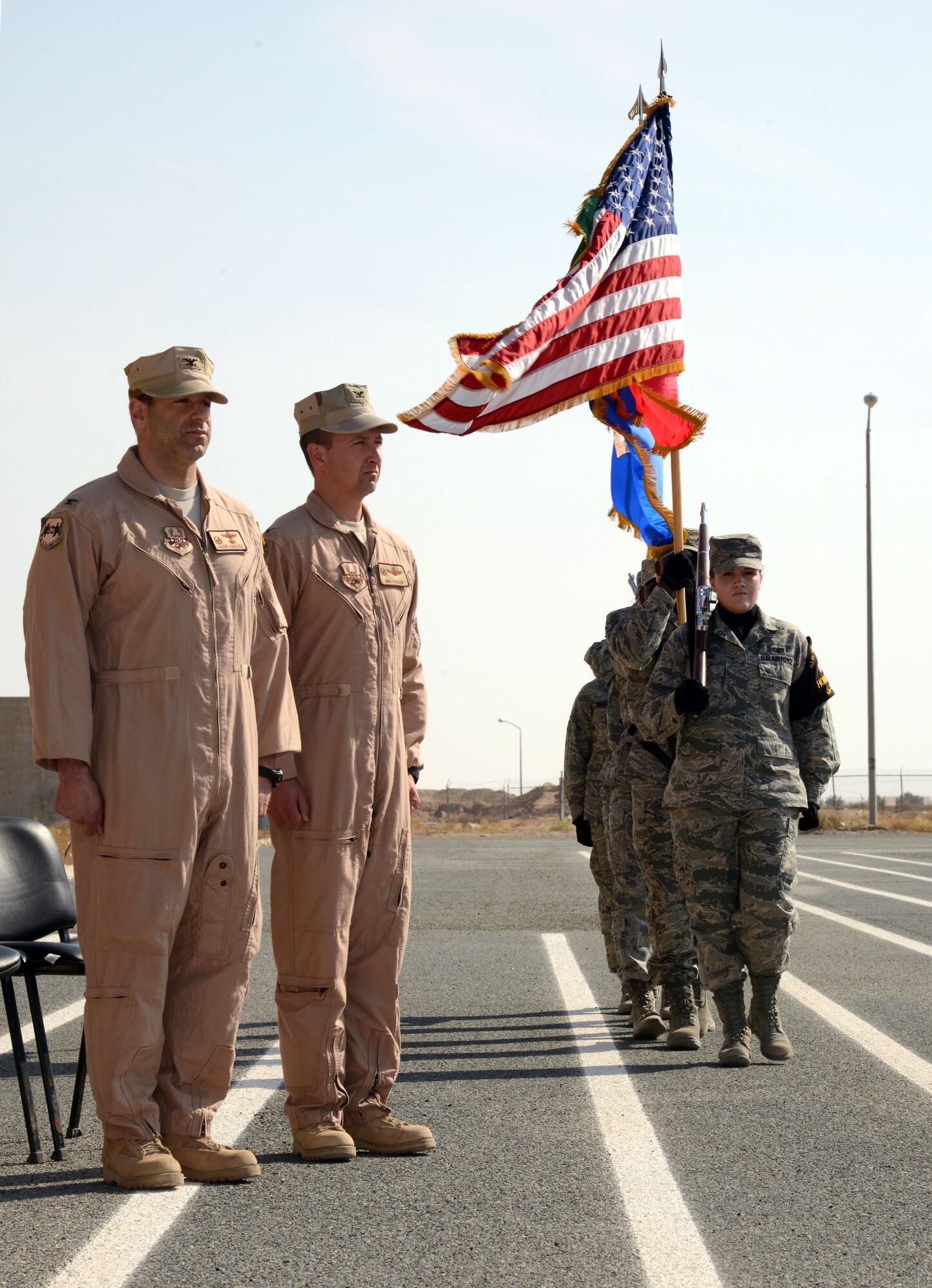 SOUTHWEST ASIA - Col. Jason Hanover, 386th Air Expeditionary Wing commander, and Col. Michael Stohler, 332nd Air Expeditionary Group commander, stand as the colors are posted during the 332nd AEG reactivation and assumption of command ceremony Nov. 16, 2014. The 332nd AEG has a storied history and is descended from the 332nd Fighter Group - the famed Tuskegee Airmen, also known as the Red Tails. (U.S. Air Force photo by Tech. Sgt. Jared Marquis/released)  