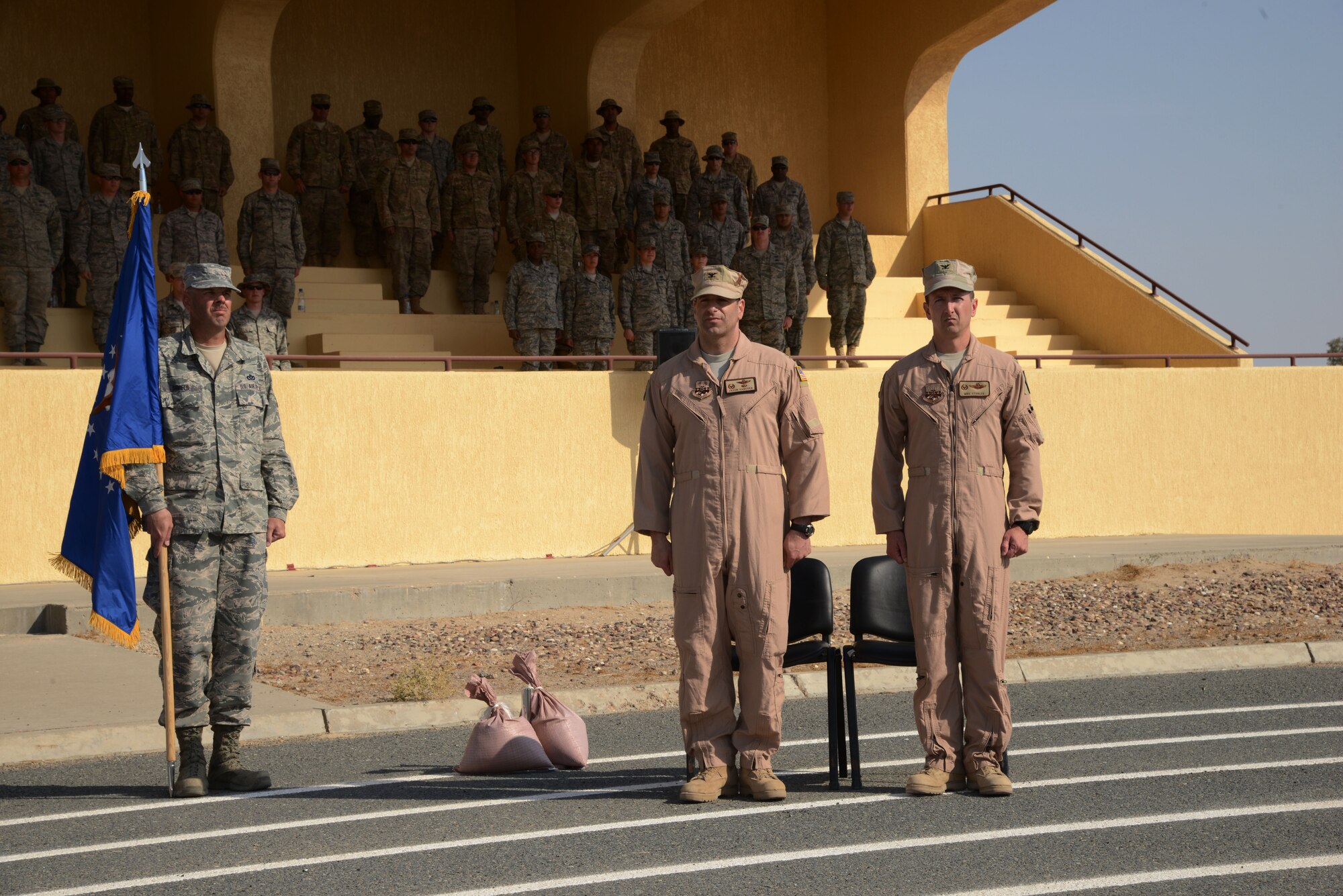 SOUTHWEST ASIA - Col. Jason Hanover, 386th Air Expeditionary Wing commander, and Col. Michael Stohler, 332nd Air Expeditionary Group commander, stand next to the newly uncased guidon while the Air Force song plays during the 332nd AEG reactivation and assumption of command ceremony Nov. 16, 2014. The 332nd AEG has a storied history and is descended from the 332nd Fighter Group, the famed Tuskegee Airmen, also known as the Red tails. (U.S. Air Force photo by Tech. Sgt. Jared Marquis/released)  