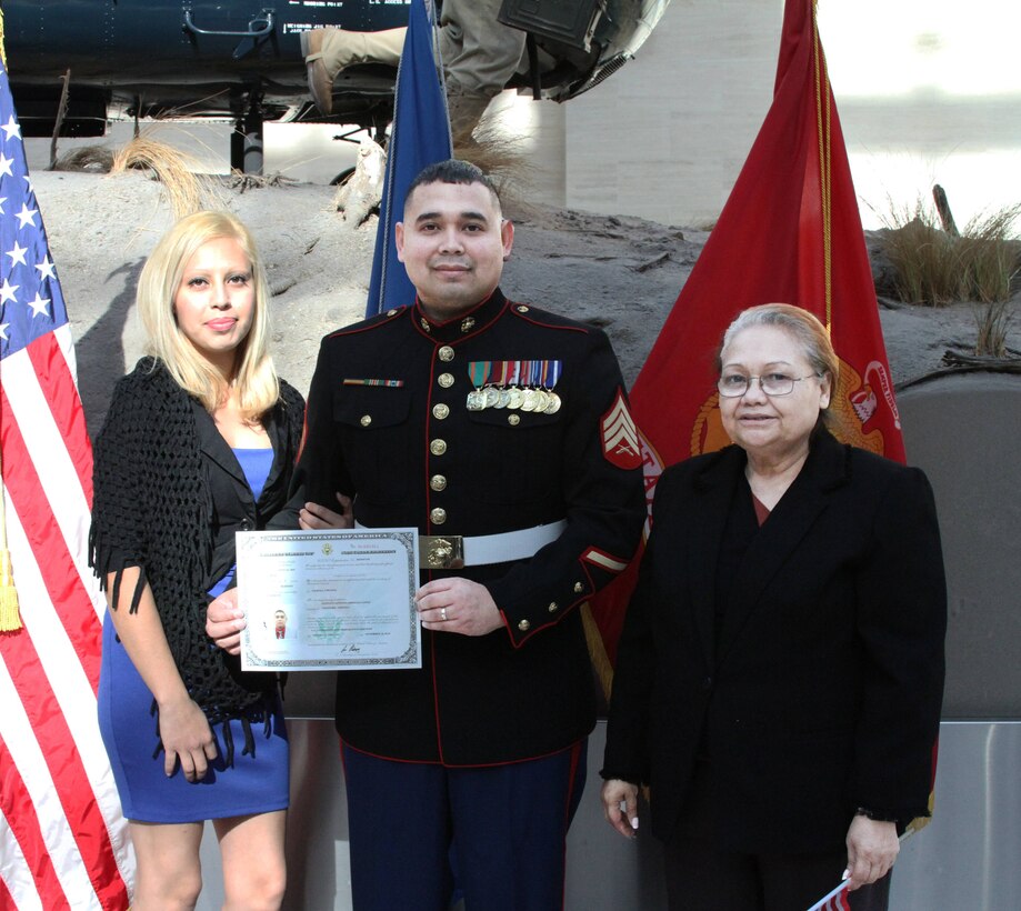 U.S. Marine Corps Sgt. Gustavo A. Arroliga, a recruiter with Recruiting Sub-Station Woodbridge and native of Nicaragua, holds his Certificate of Naturalization of citizenship Nov.  10, 2014. His wife Laura (left) and mother Mercedes Lopez (right) attended this prestigious ceremony at the National Museum of the Marine Corps.  (U.S. Marine Corps photo by Cpl. Amber Williams/Released)