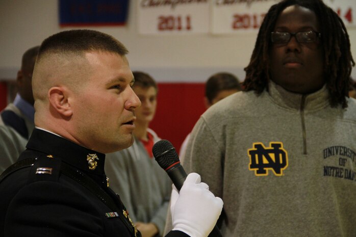 Capt. Joseph A. Haley presents a jersey to Brandon Tiassum, a defensive tackle with Park Tudor High School during the school’s fall awards assembly, Nov. 21, 2014, after being officially recognized to participate in the 2015 Semper Fidelis All-American Bowl. (Photo by Sgt Tyler Mitchell)
