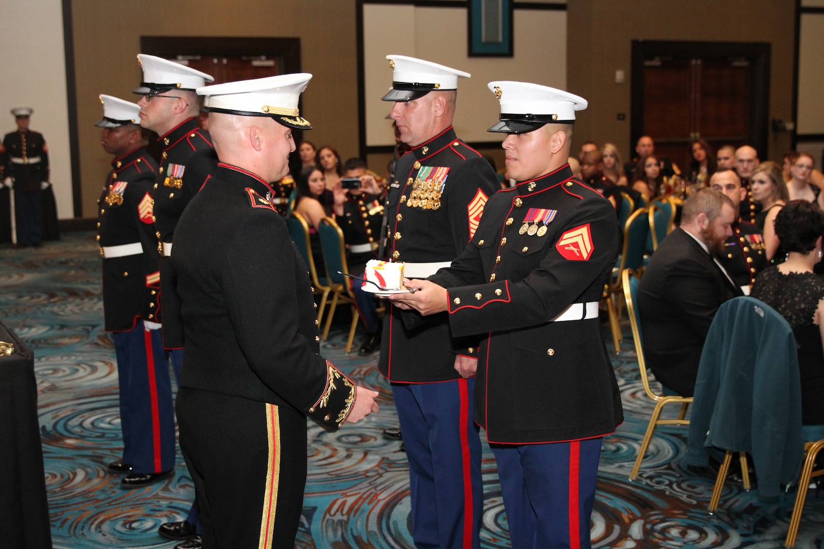 Maj. Andrew Schoenmaker, commanding officer of Marine Corps Recruiting Station Harrisburg, concludes the cake cutting ceremony with Master Gunnery Sgt. James Babst, the oldest Marine present, and Cpl. Manuel Cardenas, the youngest Marine, at the 239th Birthday Ball Celebration at the Mohegan Sun Pocono Downs, Nov. 7, 2014.