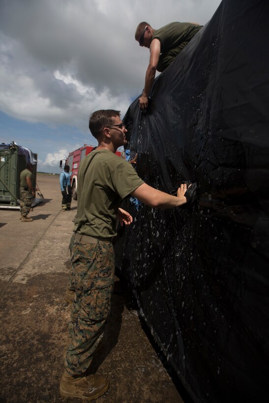 U.S. Marines with SPMAGTF - Crisis Response - Africa clean equipment in accordance with Centers for Disease Control and Prevention cleaning and decontamination guidelines, as part of the standard procedure of washing gear prior to leaving the country, while in support of Operation United Assistance in Monrovia, Liberia, Nov. 19, 2014. United Assistance is a Department of Defense operation to provide command and control, logistics, training and engineering support to U.S. Agency for International Development-led efforts to contain the Ebola virus outbreak in West African nations. (U.S. Marine Corps photo by Lance Cpl. Andre Dakis/SP-MAGTF Crisis Response Africa Combat Camera/Released)