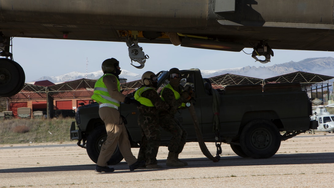 U.S. Marines with SPMAGTF Crisis Response - Africa and Spanish soldiers with Transport Helicopter Battalion 5, ground static electricity from the aircraft and prepare to sling two water bladders to the bottom of the Spanish Army CH-47 Chinook, at Colmenar de Viejo, Spain, Nov. 18, 2014. The 4,300 pound water bladders can be used to transport clean water to support troops operating in a location without potable water or when conducting humanitarian assistance missions. The training enhanced mission readiness and help build relationships between the two militaries. (U.S. Marine Corps photo by Cpl. Jeraco Jenkins/Released)