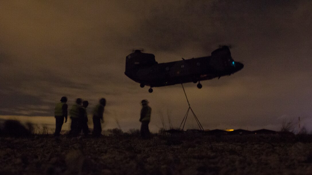 U.S. Marines with SPMAGTF Crisis Response - Africa and Spanish soldiers with Transport Helicopter Battalion 5, prepare to sling a truck to the bottom of the Spanish Army CH-47 Chinook, at Colmenar de Viejo, Spain, Nov. 19, 2014. The long distance transportation of vehicles by air can be used when conducting a disaster relief mission where vehicles are needed but key road and bridges are destroyed. The training conducted by the Marines and soldiers enhanced mission readiness and help build relationships between the two militaries. (U.S. Marine Corps photo by Cpl Jeraco Jenkins/Released).