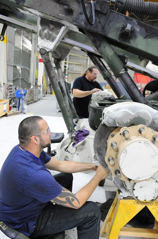 Peter Garcia (L), heavy equipment mechanic for contractor URS, and Barton Brown, heavy mobile equipment mechanic for contractor SFS/Tiburon, work on the M198 howitzer.