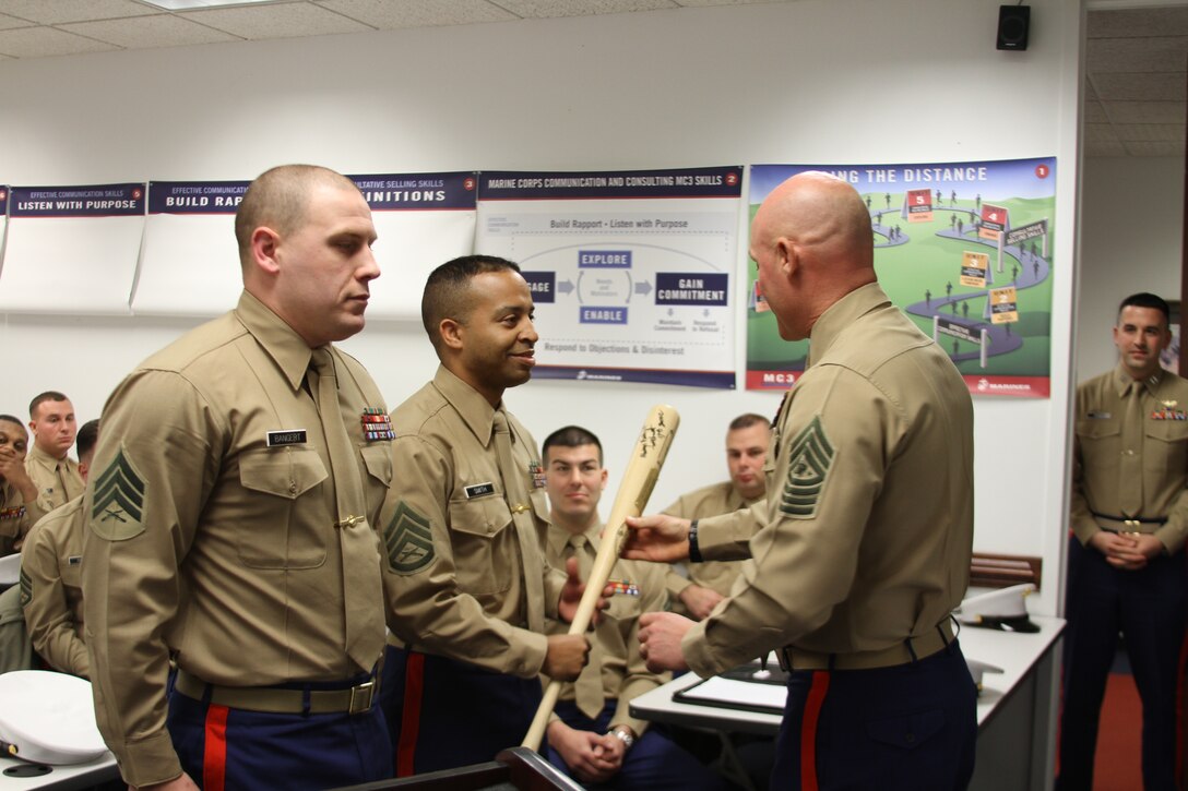 U.S. Marine Corps Sgt. Maj. Micheal Barrett presents the "Heavy Hitter" award to Staff Sgt. Quentin A. Smith, a recruiter at Recruiting Sub-Station Newport-News, Recruiting Station Richmond, Nov. 22, 2014. This award goes to a recruiter who contracts four net new contracts for that designated month. (U.S. Marine Corps photo by Cpl. Aaron Diamant/Released)