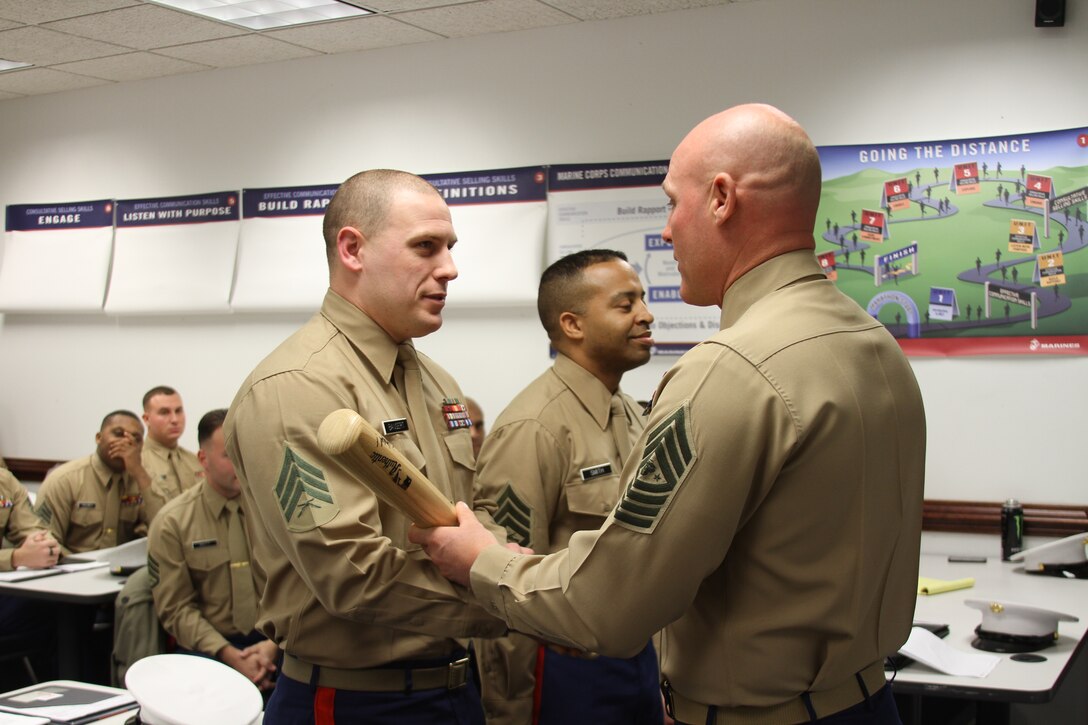 United States Marine Corps Sgt. Maj. Micheal Barrett presents the "Heavy Hitter" award to Sgt. Christopher L. Bangert, a recruiter at Recruiting Sub-Station Lynchburg, Recruiting Station Richmond, Nov. 22, 2014. This award goes to a recruiter who contracts four net new contracts for that designated month. (U.S. Marine Corps photo by Cpl. Aaron Diamant/Released)