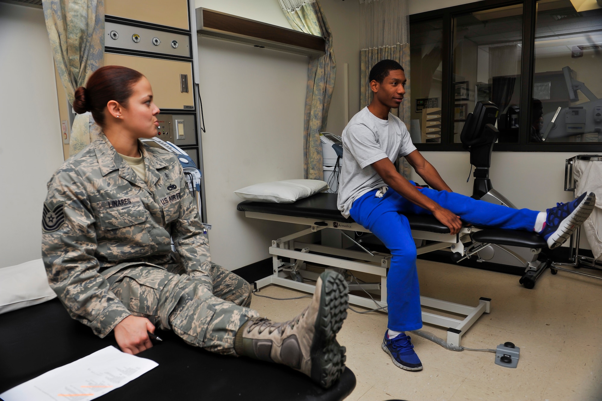 Tech Sgt. Liz Marie Linares, 51st Medical Operations Squadron physical therapy technician, shows Senior Airman Justin Morgan, 25th Aircraft Maintenance Unit weapons loader, how to perform a hamstring stretch during a physical therapy session Nov. 25, 2014, on Osan Air Base, Republic of Korea. The direct access clinic is held to provide treatment for service members who have had an acute musculoskeletal injury within seven-days prior to the visit. (U.S. Air Force photo by Senior Airman David Owsianka)