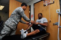 Staff Sgt. Marcos Davis, 51st Medical Operations Squadron physical therapy technician, aids Staff Sgt. Kyle Wimberly, 18th Intelligence Squadron Detachment 2 space systems analyst, with performing an exercise during a physical therapy session Nov. 25, 2014, on Osan Air Base, Republic of Korea. Wimberly is performing the exercise to regain a full range of motion and flexibility in his knee. (U.S. Air Force photo by Senior Airman David Owsianka)