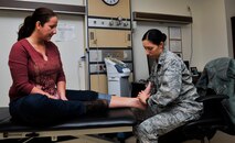 Capt. Veronica Khrakovskaya, 51st Medical Operations Squadron physical therapist, checks the foot of Lori Jonas, spouse of Capt. Jozsef Jonas, 25th Fighter Squadron pilot, during a reassessment session Nov. 25, 2014, on Osan Air Base, Republic of Korea. The direct access clinic is available from 8 a.m. to 10 a.m. on Tuesdays and Thursdays. (U.S. Air Force photo by Senior Airman David Owsianka)