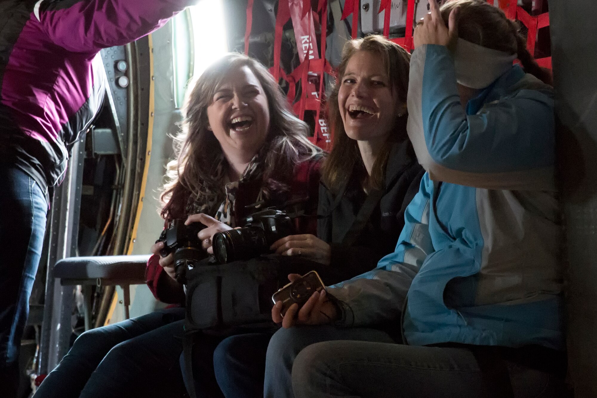 Spouses of the 374th Operations Group and 374th Maintenance Group laugh on a  C-130 Hercules flight during Operation VOLANT SPOUSE 14’ over the Kanto Plain, Japan, Nov. 24, 2014. The spouses had the opportunity to fly on the C-130 Hercules, UH-1N Huey and C-12 Huron as part of a spouse orientation day. (U.S. Air Force photo by Osakabe Yasuo/Released)