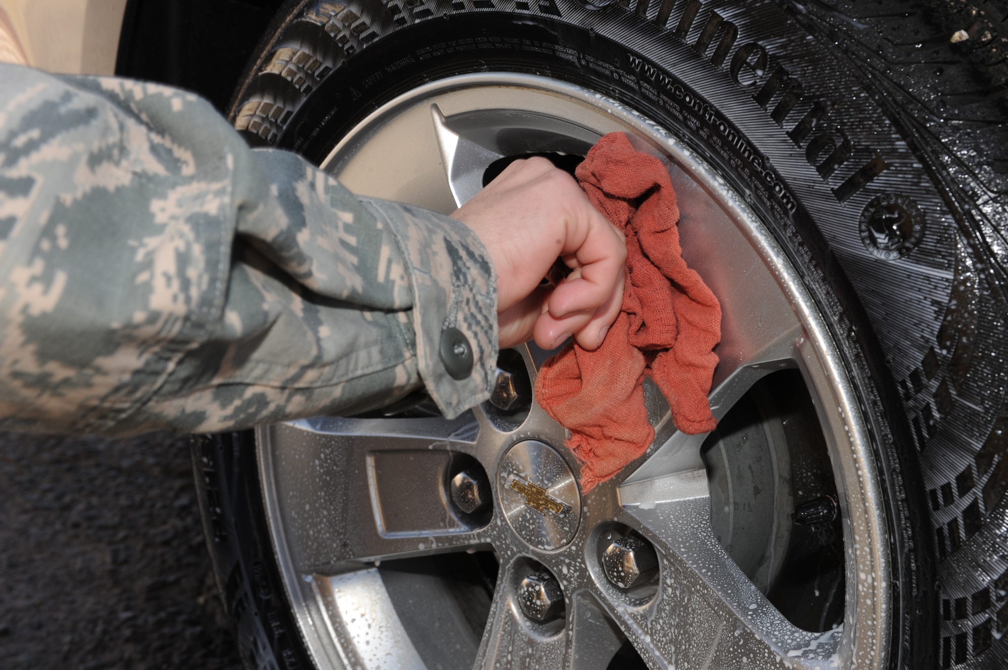 U.S. Air Force Senior Airman Andrew Liszewski, 355th Logistics Readiness Squadron vehicle operator and dispatcher, applies multi-use surface protectant to the wheels of a government-owned vehicle at Davis-Monthan Air Force Base, Ariz.,Nov. 18, 2014. The protectant gives the tires a high-gloss finish. (U.S. Air Force photo by Airman 1st Class Cheyenne Morigeau/ Released)