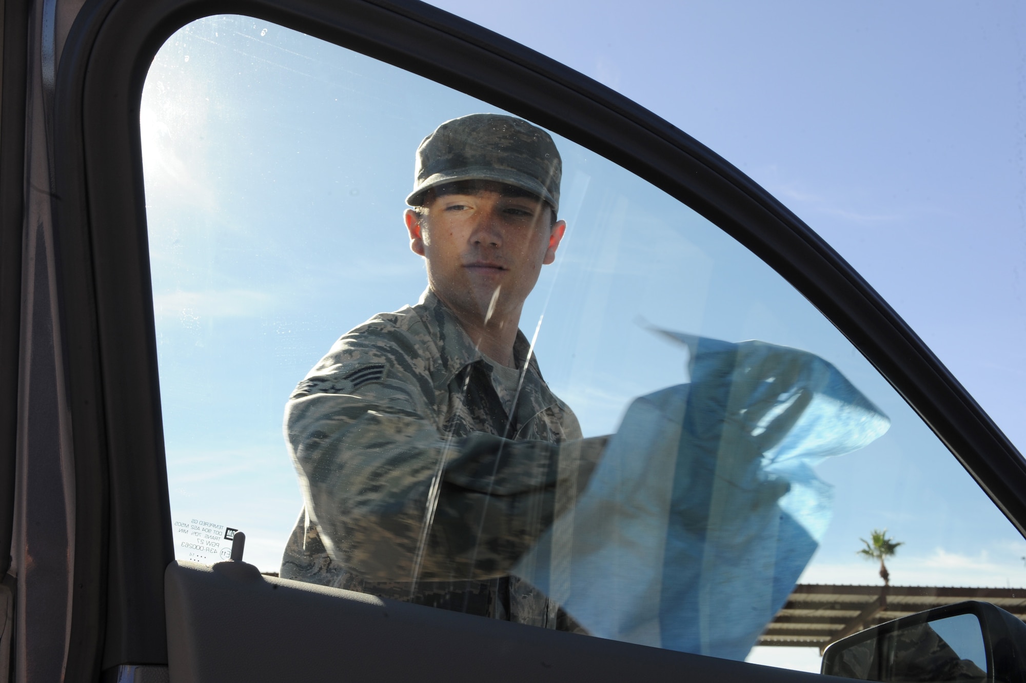 U.S. Air Force Senior Airman Andrew Liszewski, 355th Logistics Readiness Squadron vehicle operator and dispatcher, cleans the window of a government-owned vehicle at Davis-Monthan Air Force Base, Ariz., Nov. 18, 2014. Using a separate cleaner to wash the windows ensures no streaks or water spots remain on the windows for a see through appearance. (U.S. Air Force photo by Airman 1st Class Cheyenne Morigeau/ Released)