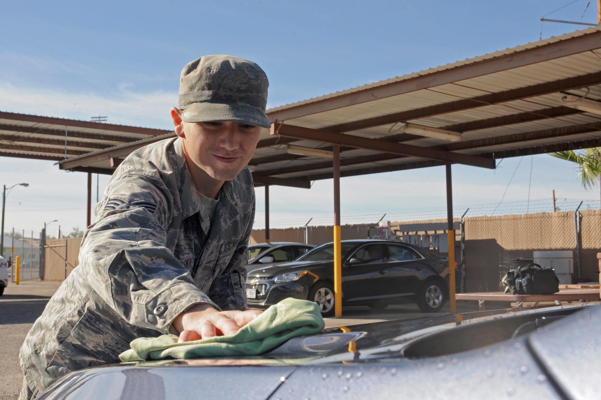 U.S. Air Force Senior Airman Andrew Liszewski, 355th Logistics Readiness Squadron vehicle operator and dispatcher, dries a government-owned vehicle at Davis-Monthan Air Force Base, Ariz., Nov. 18, 2014. Drying the vehicle with a towel removes water spots left over from the wash. (U.S. Air Force photo by Airman 1st Class Cheyenne Morigeau/ Released)