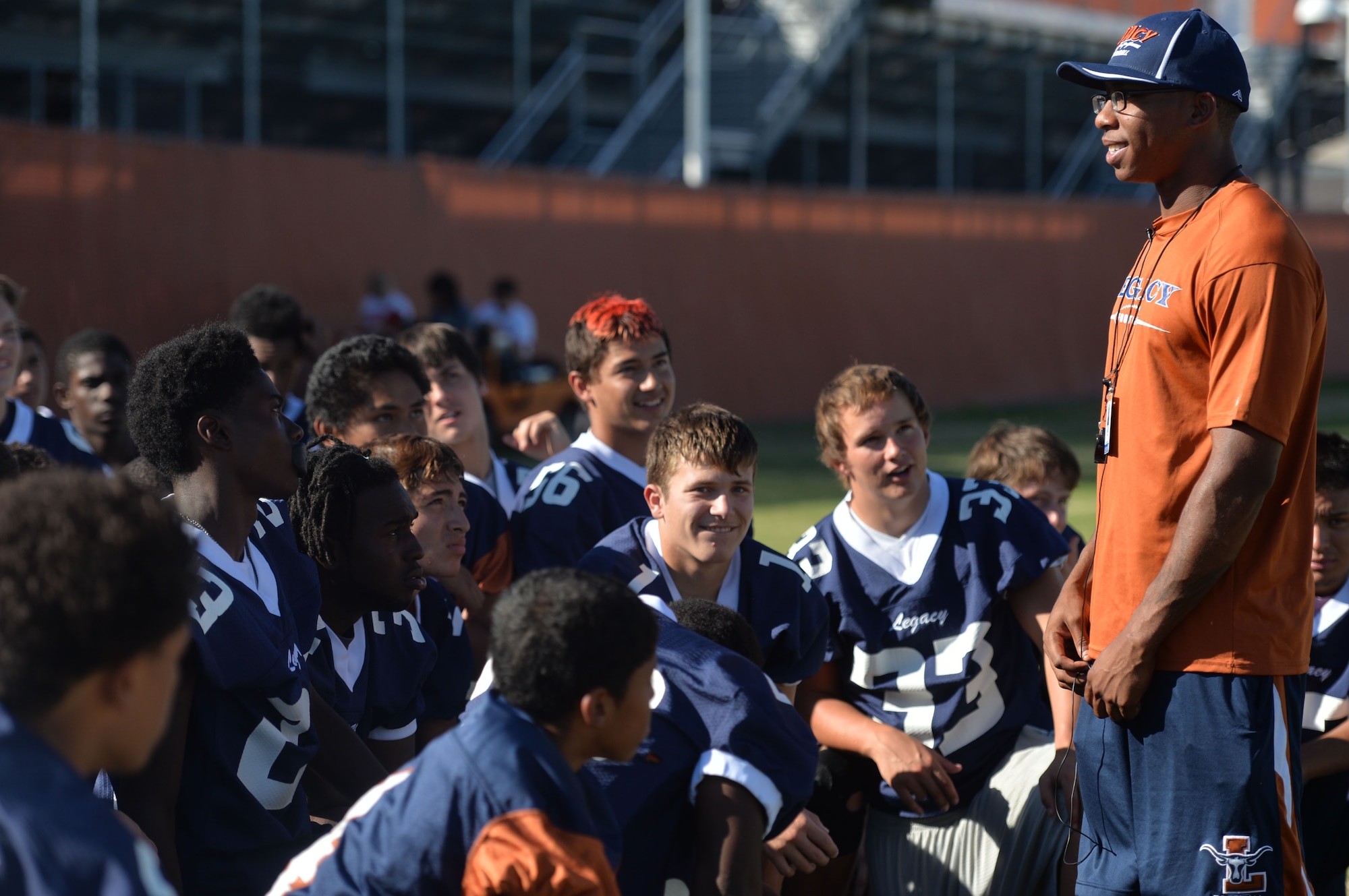 Staff Sgt. Ryan Davis, Legacy High School defensive coordinator and 99th Ground Combat Training Squadron combat arms training and maintenance instructor, talks to Legacy HS freshman and junior varsity football players about gentlemen skills during a practice in Las Vegas Oct. 1, 2014. Davis and the Legacy coaching staff are dedicated to providing their players with life lessons that extend beyond the field, including strong leadership skills and good sportsmanship qualities they can use in the future. (U.S. Air Force photo by Tech. Sgt. Nadine Barclay/RELEASED)