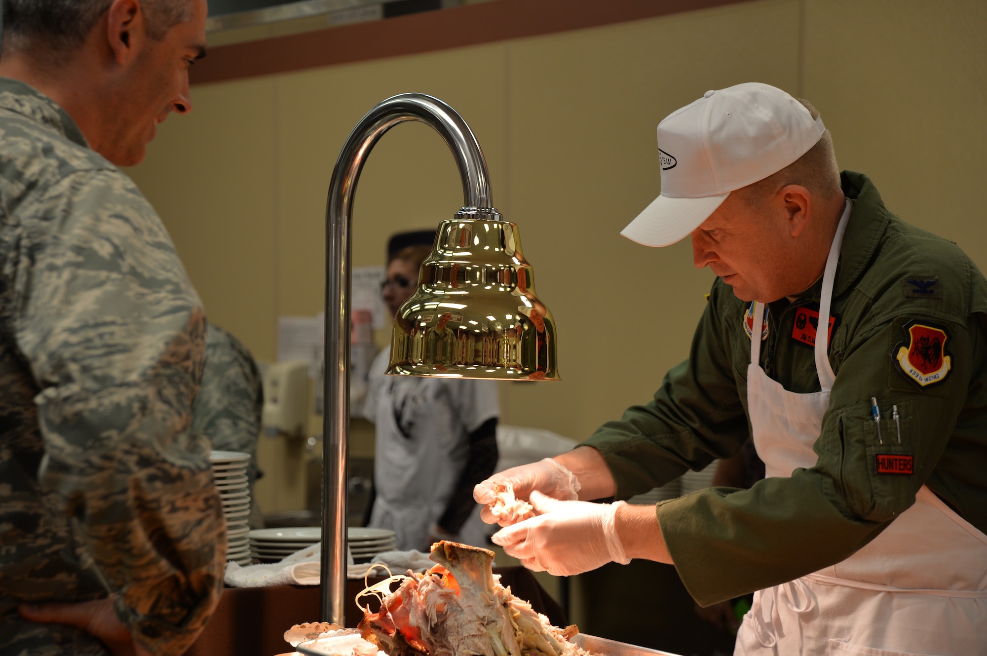 Col. James Cluff, 432nd Wing/432nd Air Expeditionary Wing commander, serves food during a Thanksgiving celebration at Creech Air Force Base, Nevada, Nov. 18, 2014. The wing hosted the event as a way to thank Airmen for their hard work, sacrifices, and dedication to the mission throughout the year. (U.S. Air Force photo by Tech. Sgt. Nadine Barclay/released)

