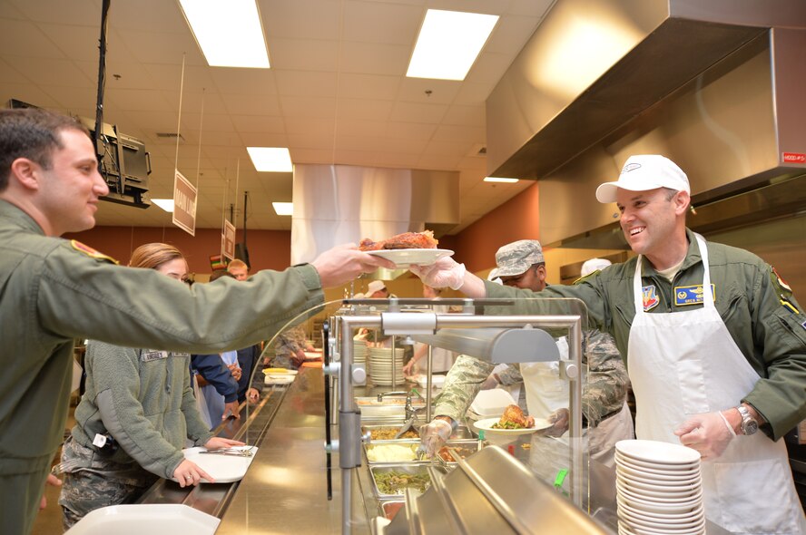 Lt. Col. Greg, right, 432nd Operation Support Squadron commander, serves Airmen lunch to 432nd Wing/432nd Air Expeditionary Wing and 799th Air Base Group Airmen during a Thanksgiving celebration at Creech Air Force Base, Nevada, Nov. 18, 2014. The wing hosted the event as a way to thank Airmen for their hard work, sacrifices, and dedication to the mission throughout the year. (Some last names have been withheld for security purposes.) (U.S. Air Force photo by Tech. Sgt. Nadine Barclay/released) 

