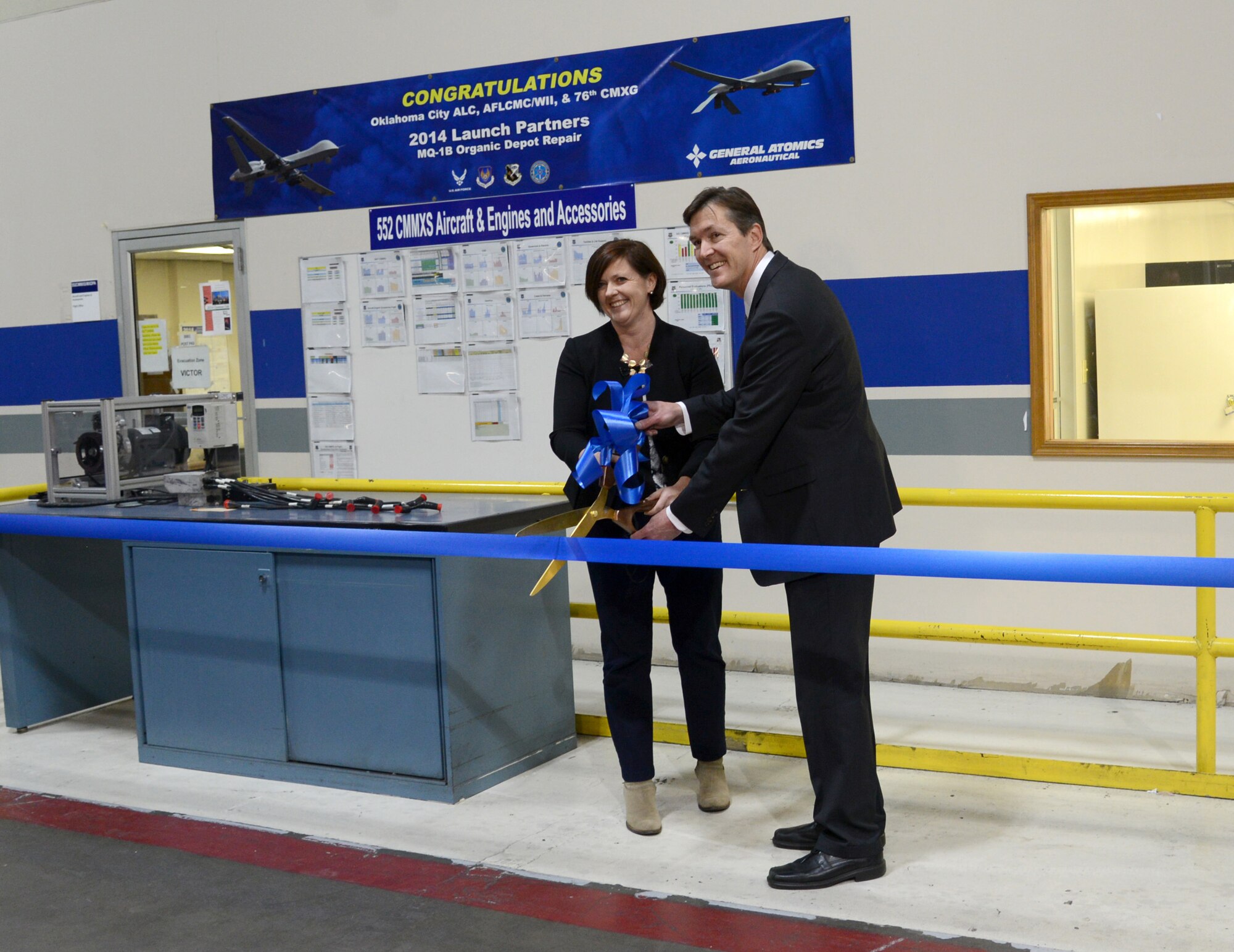 Oklahoma City Air Logistics Complex Vice Director Kevin O’Connor and General Atomics Aeronautical Systems Program Manager Maria Donovan cut the ceremonial ribbon Nov. 19 for the activation of the Air Force’s first depot-level overhaul/repair line for the MQ-1 Predator and MQ-9 Reaper unmanned aerial vehicles in Bldg. 3001. (Air Force photo by Kelly White)
