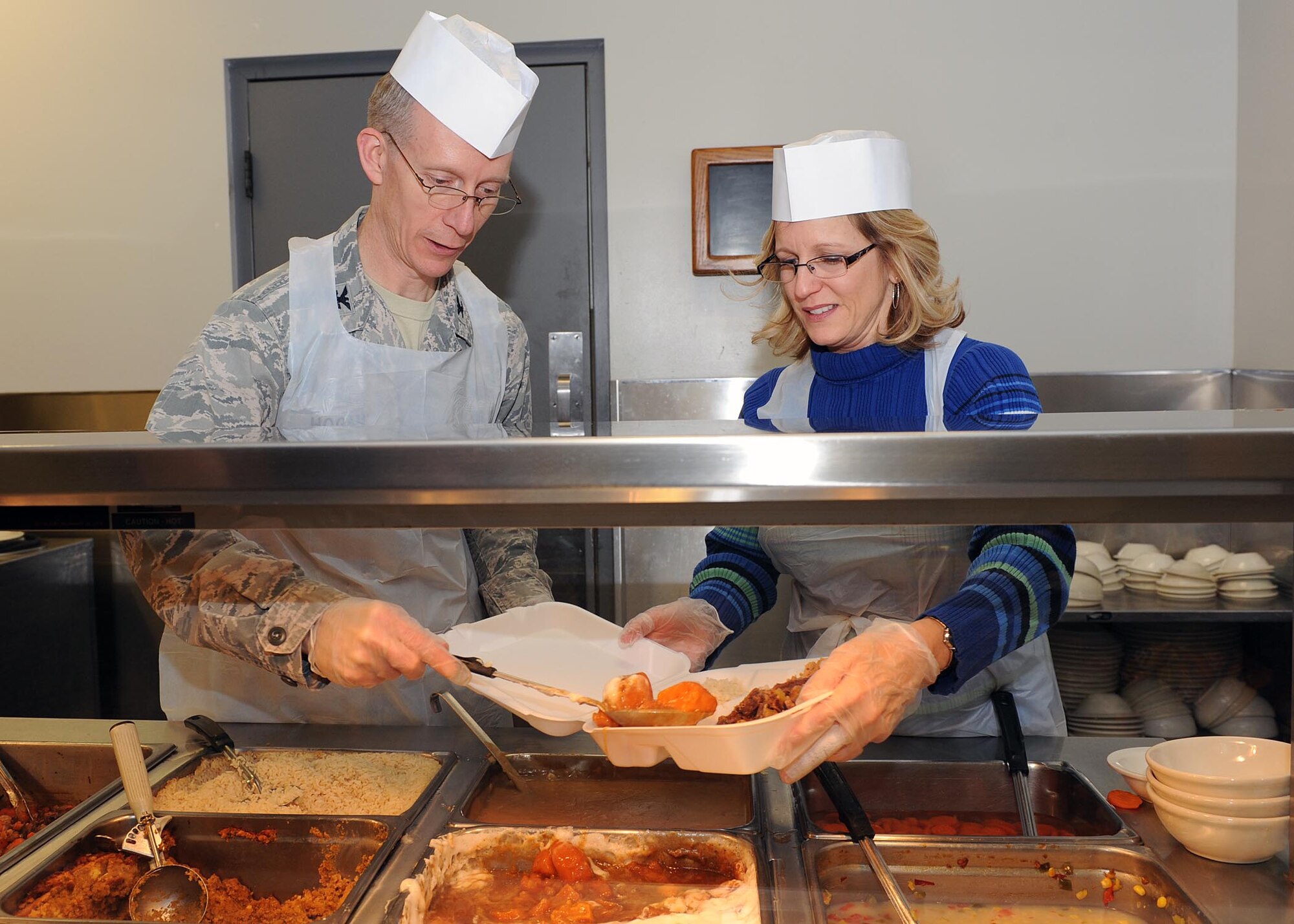 WRIGHT-PATTERSON AIR FORCE BASE, Ohio - Col. Charles Hogan, National Air and Space Intelligence Center vice commander, and his wife Christine serve
dinner at the Pitsenbarger Dining Facility here Nov. 19. Each year, the
dining facility staff prepares a special Thanksgiving-themed dinner for
patrons. Throughout the evening, several Wright-Patterson senior leaders
served the dinner to Airmen as a gesture of appreciation for their hard
work. (U.S. Air Force photo/Staff Sgt. Eunique P. Thomas)

