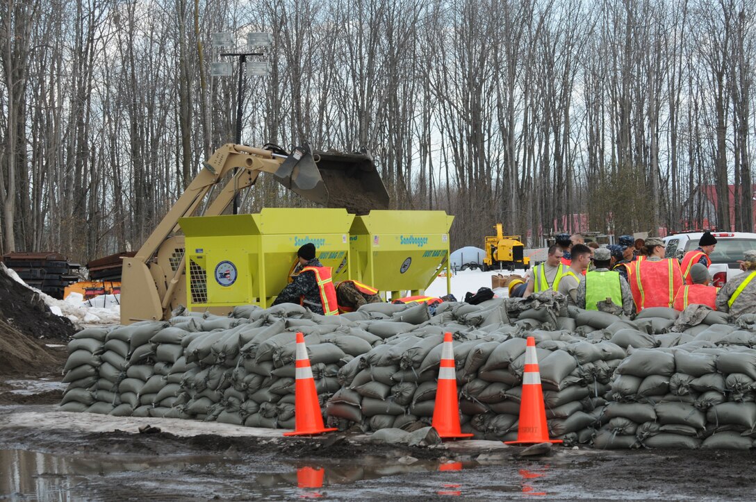 New York National Guardsmen pile sandbags onto pallets to be used near Erie County Community College in Williamsville, N.Y., Nov. 24, 2014 as the area prepared for potential flooding from snow melt and rain after a large lake effect snow storm. (U.S. Air National Guard photo by Tech. Sgt. Brandy Fowler)